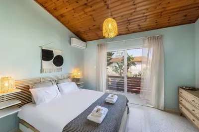 a bedroom with a large bed and a window at Laranca Oneiro Seaside Villa in Pervolia