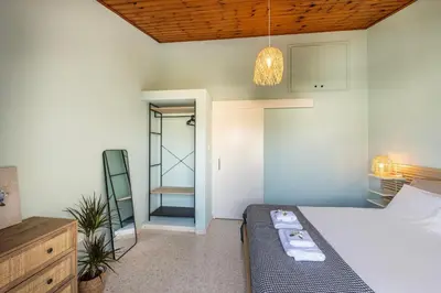 a bedroom with a bed and a dresser and a mirror at Laranca Oneiro Seaside Villa in Pervolia