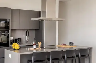 a kitchen with a large island with bar chairs at Protaras Aqua Pearl Villa 9 in Protaras