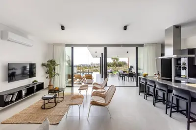 a kitchen and living room with a table and chairs at Protaras Aqua Pearl Villa 9 in Protaras