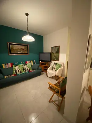a living room with a blue couch and a tv at Sunny 2BR Home in Paralimni Near Beaches,Protaras! in Paralimni