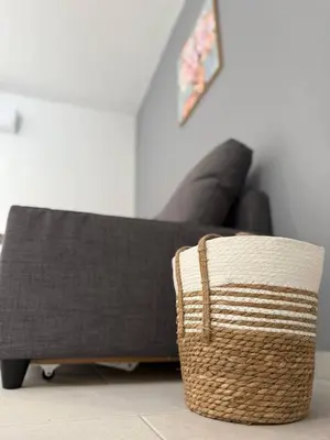 a couch in a living room with a basket at Ayia Napa 2BR - Prime Location in Ayia Napa