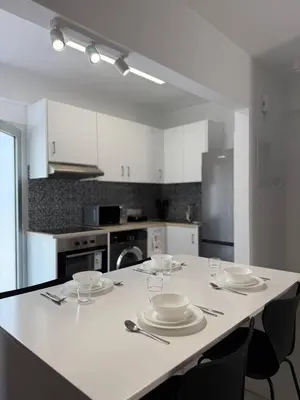 a kitchen with a table with plates and glasses on it at Ayia Napa 2BR - Prime Location in Ayia Napa