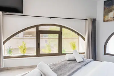a bed with two pillows in front of a window at Sweet Bonanza Studio in Larnaka