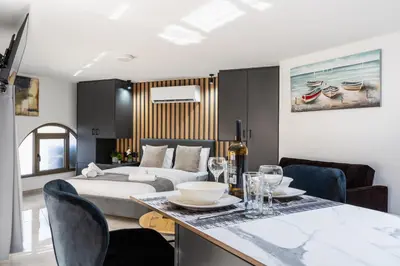 a living room with a bed and a table with chairs at Sweet Bonanza Studio in Larnaka