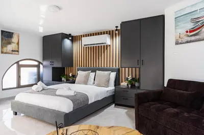 a bedroom with a large bed and a couch at Sweet Bonanza Studio in Larnaka