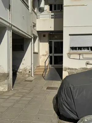 a building with a black tarp on a sidewalk at River Court, Flat 8 in Nicosia
