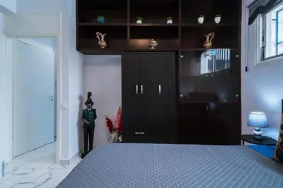 a bedroom with a black cabinet and a bed at Central & Cozy Larnaca Suite in Larnaka