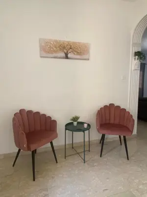 two chairs and a table in a room at Sweet Home Apartment 3-Bedrooms in Larnaka