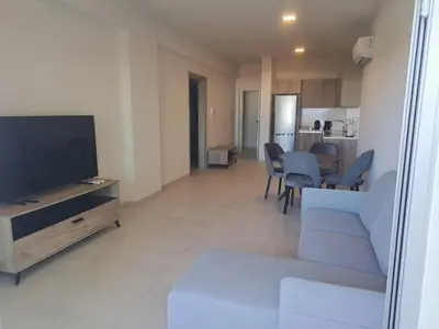 a living room with a flat screen tv and a couch at Modern Cosy Holiday Apartment in Paralimni