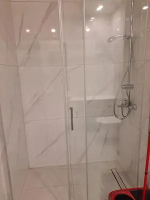 a bathroom with a shower with a glass door at Modern Cosy Holiday Apartment in Paralimni