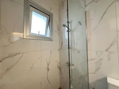 a bathroom with a shower and a window at Home For You - Holiday Apt Larnaca in Larnaka