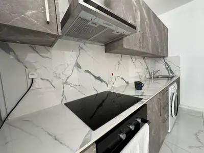 a kitchen with a marble counter top with a stove at Home For You - Holiday Apt Larnaca in Larnaka