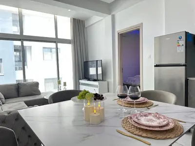 a living room with a table with plates and wine glasses at Home For You - Holiday Apt Larnaca in Larnaka