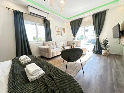 a bedroom with a large bed and a couch at Home For You - Holiday Apt Larnaca in Larnaka