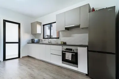 a kitchen with white cabinets and a stove top oven at City Centre Modern Boho Stay in Nicosia
