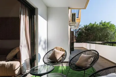 a balcony with three chairs and a table and a couch at City Centre Modern Boho Stay in Nicosia