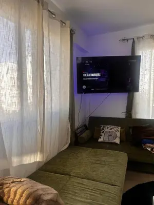 a living room with a couch and a flat screen tv at Makenzy 2 Bedrooms Apartment for rent in Larnaka