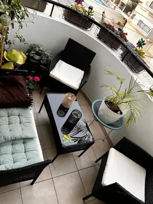 a balcony with a chair and a table and plants at Makenzy 2 Bedrooms Apartment for rent in Larnaka