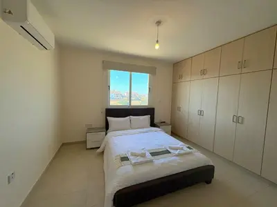 a bedroom with a large bed and a window at Sunrise Palette Suites in Larnaka