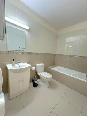 a bathroom with a toilet and a sink and a tub at Sunrise Palette Suites in Larnaka