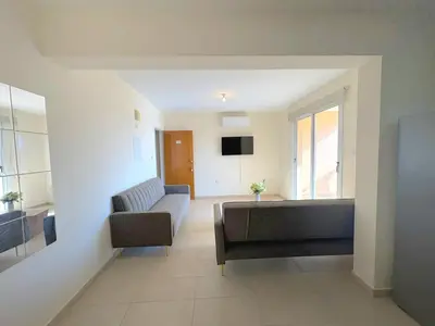 a living room with a couch and a tv at Sunrise Palette Suites in Larnaka