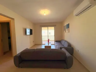 a living room with a couch and a tv at Sunrise Palette Suites in Larnaka