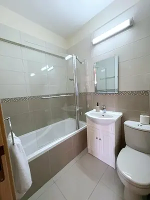 a bathroom with a tub and a toilet and a sink at Sunrise Palette Suites in Larnaka