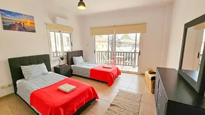 a bedroom with two beds and a flat screen tv at SKY Way City Apartment, 150m from Chabad Lubavitch in Larnaka