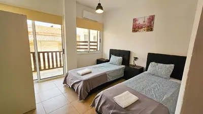 a bedroom with two beds and a balcony at SKY Way City Apartment, 150m from Chabad Lubavitch in Larnaka