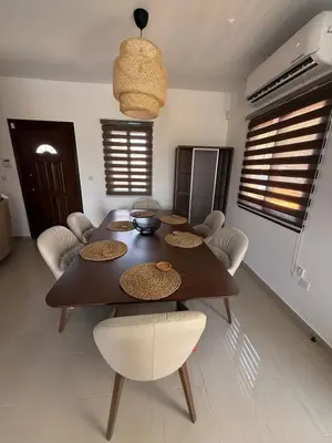 a dining table and chairs in a living room at Dene Hollow kapparis in Paralimni