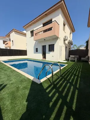 a villa with a swimming pool in front of a house at Dene Hollow kapparis in Paralimni