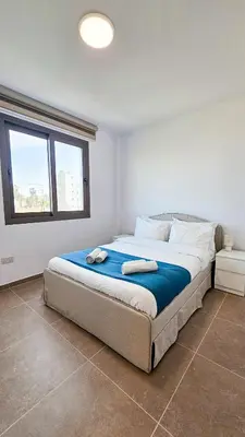 a bedroom with a bed with two towels on it at Beachside Breeze Apartment in Larnaka
