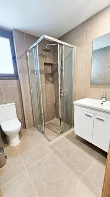 a bathroom with a shower and a toilet and a sink at Beachside Breeze Apartment in Larnaka