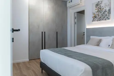 a bedroom with a large white bed and a closet at 26 Suites in Limassol