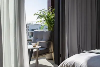 a bedroom with a chair and a table next to a window at 26 Suites in Limassol
