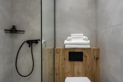 a bathroom with a shower and a pile of towels at 26 Suites in Limassol