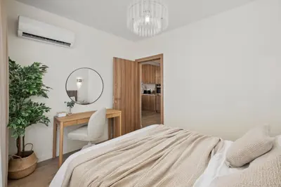 a bedroom with a bed and a desk and a mirror at The Serene Suite in Larnaka