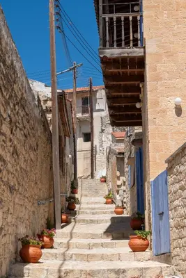 an alley with stairs and potted plants on it at Traditional Stone House in Vouni, Quiet Stay with Courtyard & BBQ in Vouni
