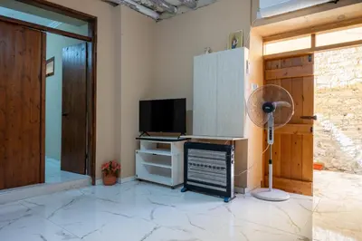 a room with a desk with a television and a fan at Traditional Stone House in Vouni, Quiet Stay with Courtyard & BBQ in Vouni