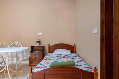 a small bedroom with a bed and a sink at Traditional Stone House in Vouni, Quiet Stay with Courtyard & BBQ in Vouni