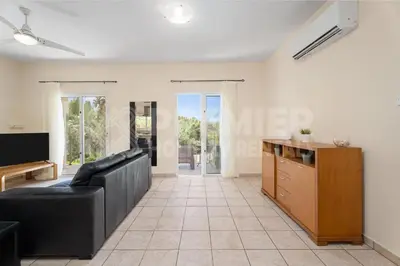 a living room with a black couch and a tv at Villa Coral in Paralimni