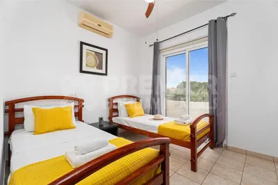 two beds in a room with a window at Villa Coral in Paralimni