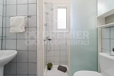 a white bathroom with a shower and a toilet at Villa Coral in Paralimni