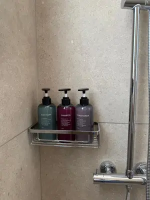 three bottles ofodorizers sit on a shelf in a bathroom at Kroisou Comfort Stay in Ayios Dhometios