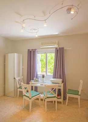a kitchen with a table and chairs and a window at Nissi Maria Villa in Ayia Napa