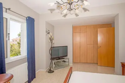 a living room with a television and a window at Nissi Maria Villa in Ayia Napa