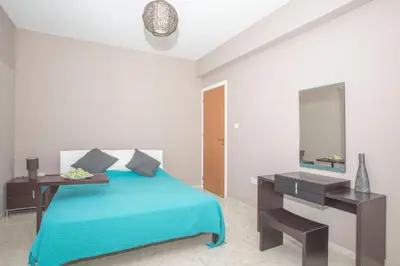 a bedroom with a bed with a desk and a mirror at Nissi Maria Villa in Ayia Napa