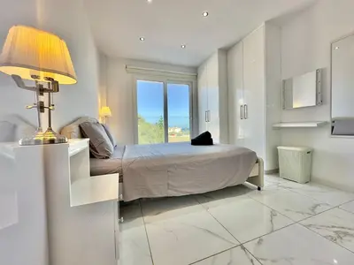 a bedroom with a bed with a lamp and a window at Lumière Retreat 2 in Larnaka