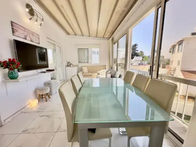 a dining room with a glass table and chairs at Lumière Retreat 2 in Larnaka